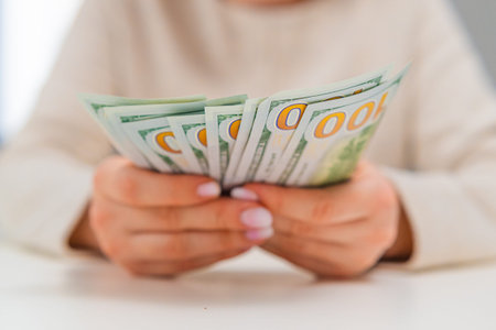Close up of female hands recounting US dollars. Financial planning, expense control and money management theme.の写真素材