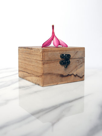 Tropical pink flower and wooden box isolated on white