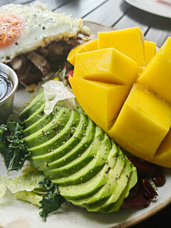 Open brioche sandwich with mint avocado, poached egg served with arugula and cherry tomato. Healthy breakfast.の写真素材