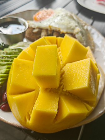 Open brioche sandwich with mint avocado, poached egg served with arugula and cherry tomato. Healthy breakfast.の写真素材