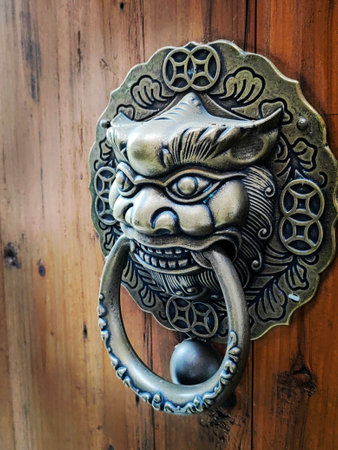 Metal locks in the shape of mythological animals such as dragons or tigers. Ancient wooden doors with ancient bronze decorations.の写真素材