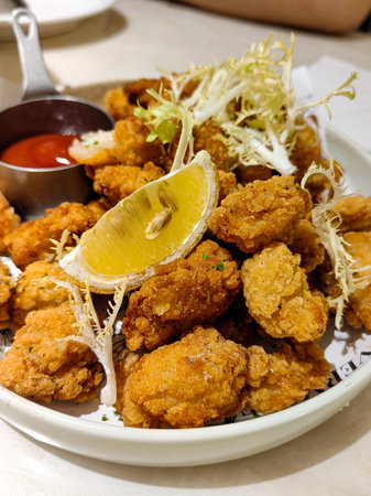 Marinated grilled healthy chicken breasts cooked on a summer BBQ and served with fresh herbs and lemon juice on a wooden board, close up viewの写真素材
