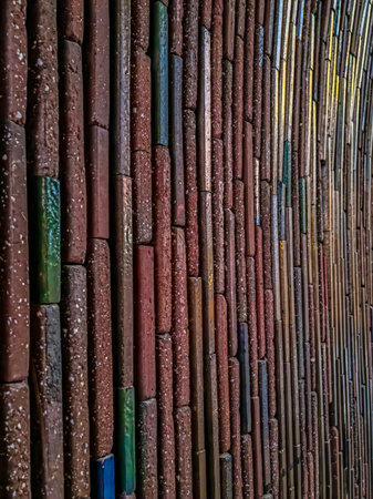 Featured wall outdoors made of handmade brick ceramic in terracotta colors and some blue and green...