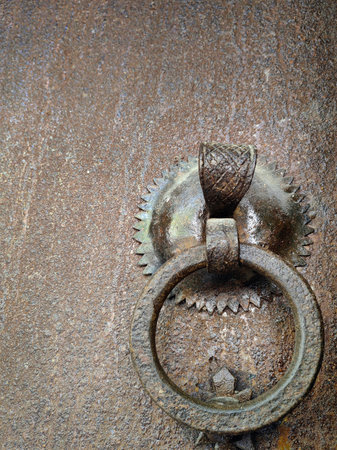 Metal iron bronze chinese style door locker on a brown aged wooden doorの写真素材