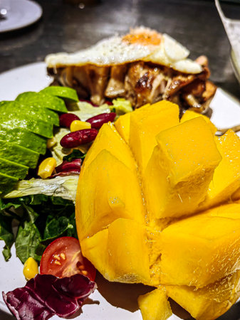 Egg, avocado and dry tomato and a bowl of yogurt, mango, chestnuts and coffee powder. Healthy meal...