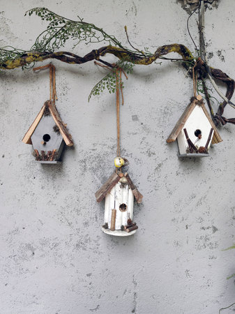 Birdhouse hanging on the wall. Painted wooden birdhouse hanging from the wall with cement grunge...
