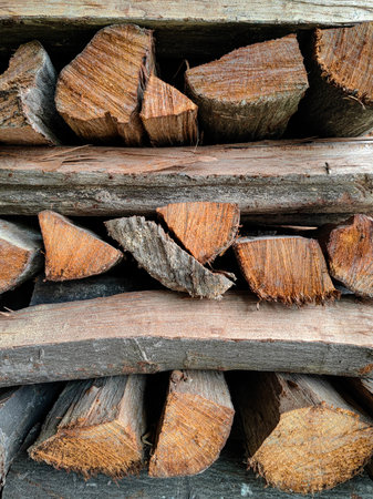 Stack of firewood, wood logs texture background. Pile of chopped fire wood prepared for winter.