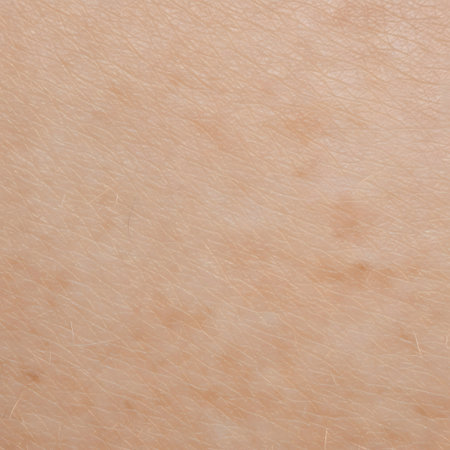 The image reveals the intricate details of the skin's surface, including subtle lines, pores, fine hairs, and slight variations in pigmentation. The overall tone is a light, natural skin colorの写真素材