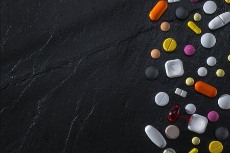 Various Tablets And Pills On A Black Stone Backgroundの写真素材