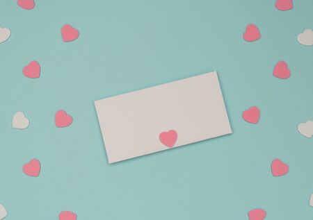 Valentine's Day blue background with white envelope and pink and white hearts. Valentine greeting card. Flat lay style.の写真素材