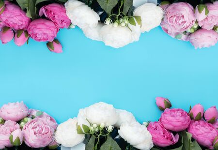 Pink and white flowers on blue background. Mothers Day, Spring concept. Greeting, invitation card. Flat lay, top view style with copy space for your text.の写真素材