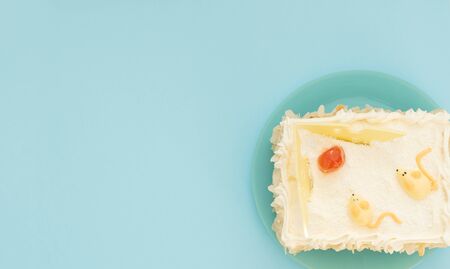 Cheese cake with two figures of mouse and slices of cheese on blue background. Holiday concept. Flat...