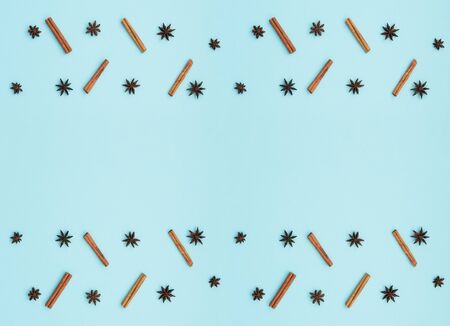 Cinnamon sticks and anise stars on blue background. Cooking concept. Winter and holiday spices. Flat lay, top view with copy space for your text.の写真素材