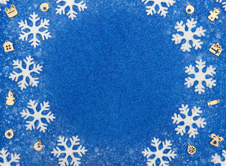 Christmas or winter blue background with white snowflakes, Xmas wooden decorations and snow. New...