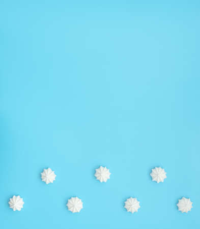 Delicious white merengues on blue background. Happy day, breakfast, good morning concepts. Time for...