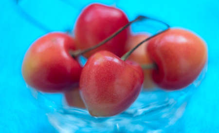 Fresh cherries close up macro on blurred blue background. Selective focus. Natural, organic, vitamin...
