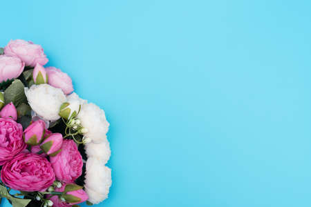 Pink and white flowers on blue background. Mother's Day, Spring concept. Greeting, invitation card. Flat lay, top view style with copy space for your text.の写真素材