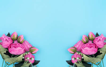 Pink flowers on blue background. Mother's Day, Spring concept. Greeting, invitation card. Flat lay, top view style with copy space for your text.の写真素材