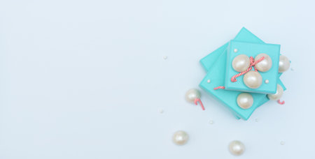 Blue gift boxes with Christmas canes, big and small pearl beads on white background. Selective focus. Xmas or holiday, time for shopping concept. Christmas, shopping banner. Top view with copy space.の写真素材