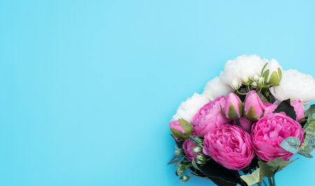 Pink and white flowers on blue background. Mother's Day, Spring concept. Greeting, invitation card. Flat lay, top view style with copy space for your text.の写真素材
