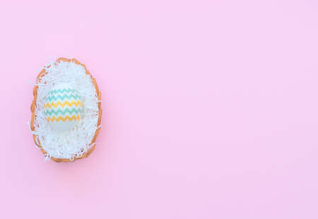 Decorated Easter egg lies in the basket on pink background. Happy Easter holiday concept. Greeting,...