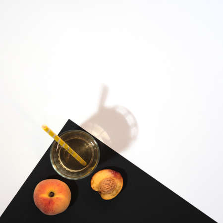 Peach, nectarine and glass of peach juice on black and white background. Flat lay style with copy space. Summertime conceptの写真素材