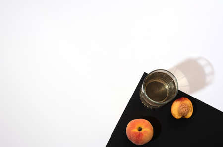 Peach, nectarine and glass of peach juice on black and white background. Flat lay style with copy space. Summertime conceptの写真素材