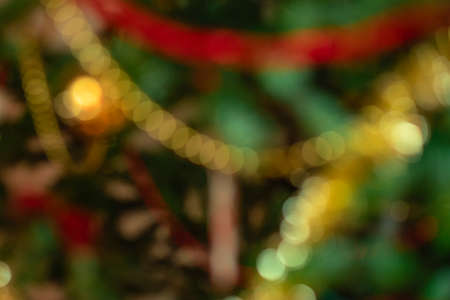 Abstract defocused Christmas or New Year background with blurred decorated Xmas tree close up. Holiday concept. Greeting or invitation cardの写真素材