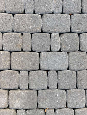 Grey stone blocks close up. Texture of brick wall, road or pavement