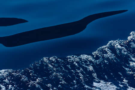 Defocused blue sea water and diagonal wave with white foam and bubbles abstract background. Selective focusの写真素材