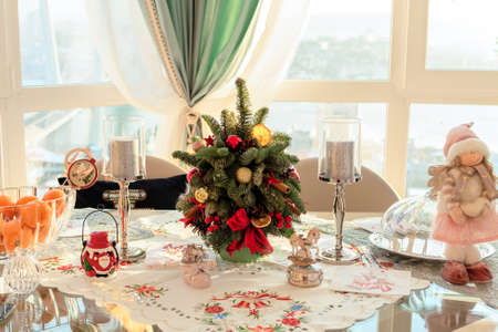 Christmas tables cape decorations with small Xmas tree. Concept of preparation for Xmas or New Year holidaysの写真素材