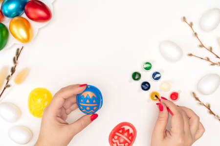 Female hands painting easter eggs using a stencil. Happy Easter concept. Process of crafting. Flat...