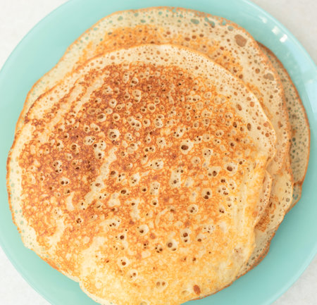Homemade pancakes on blue plate. Maslenitsa, spring festival concept. Russian traditional food....
