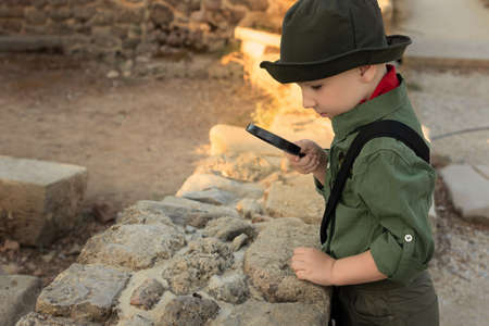 Boy archaeologist in khaki clothes studying the ruins of an ancient city. Diverse, non-traditional jobs conceptの写真素材