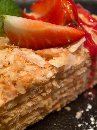 Napoleon cake with a pieces of fresh strawberries close up with selective focus.の写真素材
