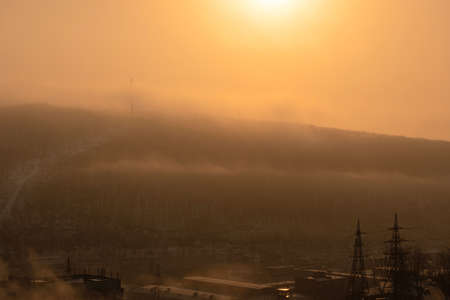 Fog and orange sunlight at the winter morning in the city. Selective focusの写真素材