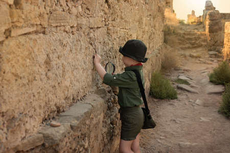 Boy archaeologist in khaki clothes studying the ruins of an ancient city. Diverse, non-traditional jobs conceptの写真素材