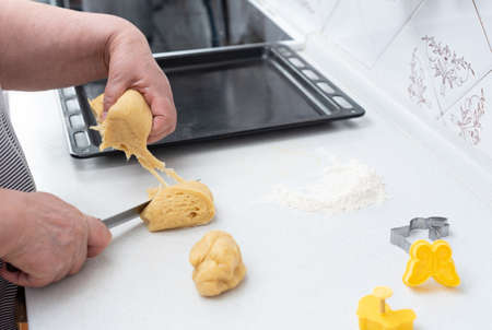 Senior woman hands making cookies from dough for Easter day. Happy Easter concept. Process of making...