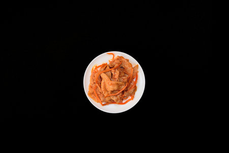 Delicious asian soy vegan meat salad on white plate on black background. Selective focus. Asian food...