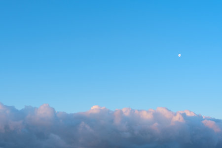 Bright blue sky with white fluffy clouds and the Moon. Beauty of nature. Aerial natural background. High quality photoの写真素材