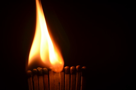 Line of lighted matches on black background.の写真素材