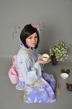 A girl in a yukata next to cherry twigsの写真素材