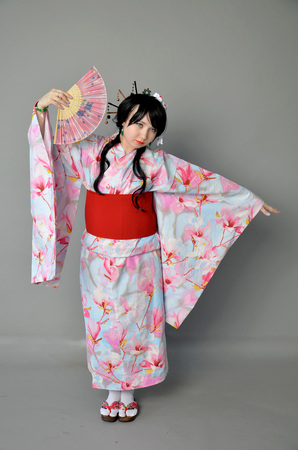 A girl in a yukata next to cherry twigsの写真素材