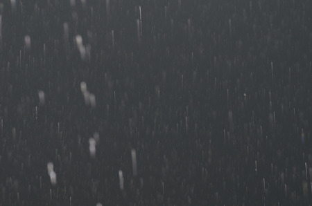 Raindrops on black glass on black glass