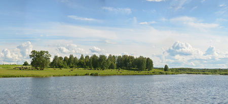 Spring summer landscape blue sky clouds Narew river boat green trees countryside grass Poland water leavesの写真素材