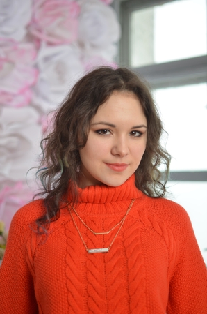 Sensual beautiful girl posing in red sweater. Girl with long curly hair.の写真素材