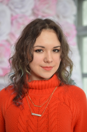 Sensual beautiful girl posing in red sweater. Girl with long curly hair.の写真素材