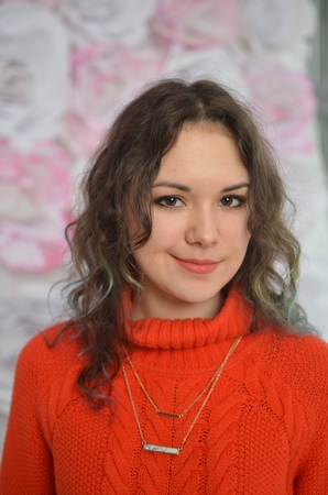 Sensual beautiful girl posing in red sweater. Girl with long curly hair.の写真素材