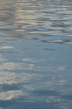 reflection of blue sky with white clouds in water, abstract background.の写真素材