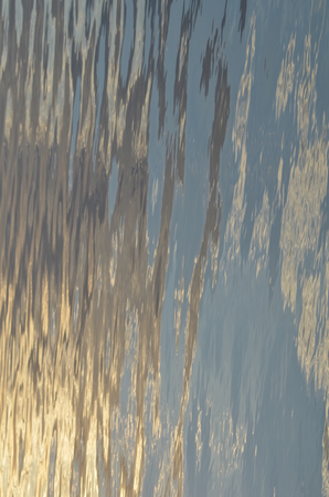 reflection of blue sky with white clouds in water, abstract background.の写真素材
